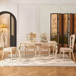 Bright dining room setting showcasing an ornate ivory dining table with gold accents and matching floral chairs.